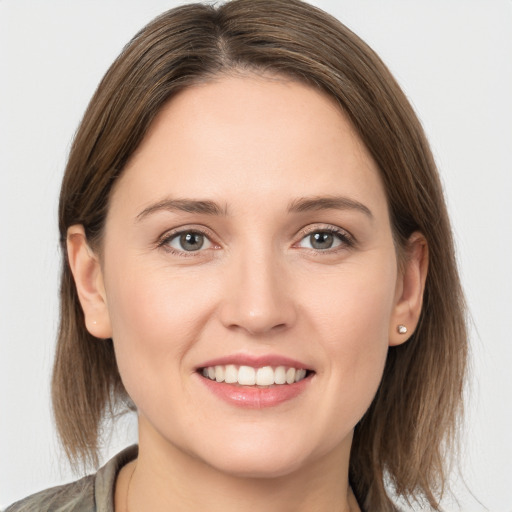 Joyful white young-adult female with medium  brown hair and grey eyes