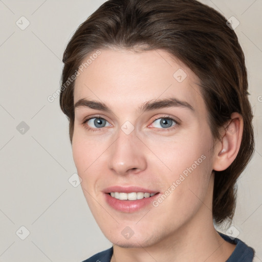 Joyful white young-adult female with medium  brown hair and grey eyes