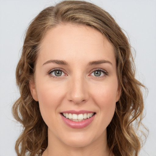 Joyful white young-adult female with long  brown hair and green eyes