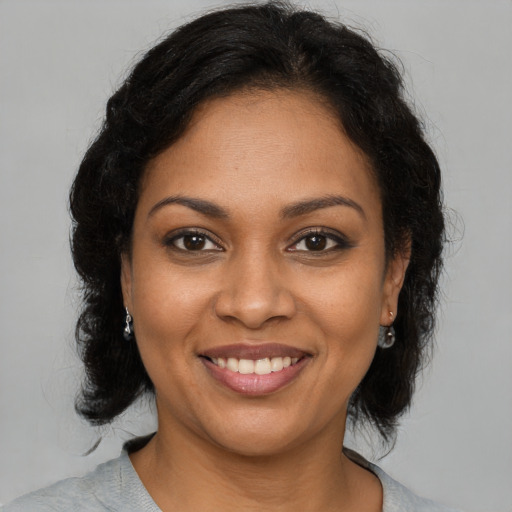Joyful black young-adult female with medium  brown hair and brown eyes