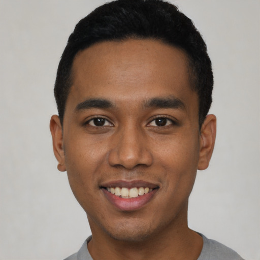 Joyful black young-adult male with short  black hair and brown eyes
