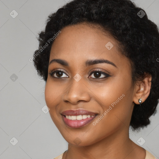 Joyful black young-adult female with long  black hair and brown eyes