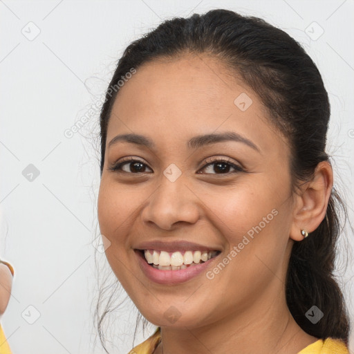 Joyful latino young-adult female with long  brown hair and brown eyes