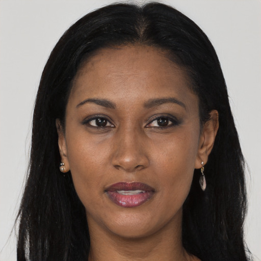 Joyful black young-adult female with long  black hair and brown eyes