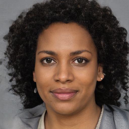 Joyful black young-adult female with long  black hair and brown eyes