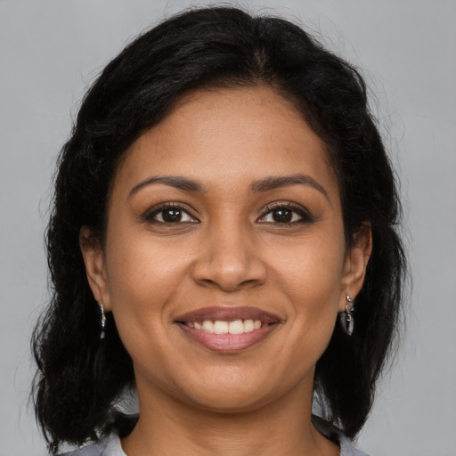 Joyful latino young-adult female with medium  brown hair and brown eyes