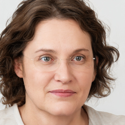 Joyful white adult female with medium  brown hair and green eyes