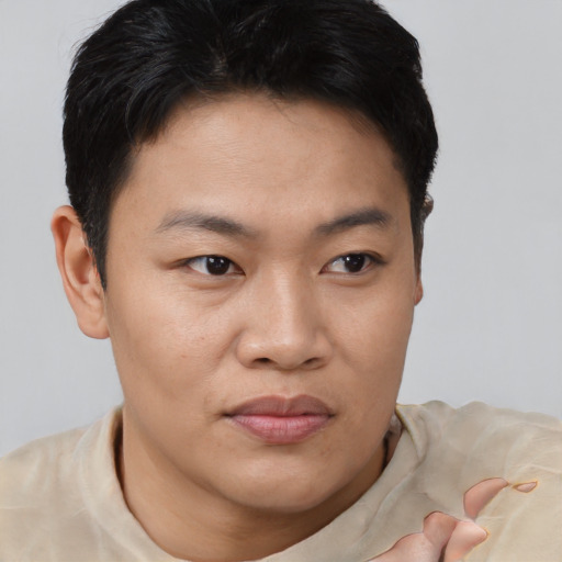 Joyful asian young-adult male with short  brown hair and brown eyes