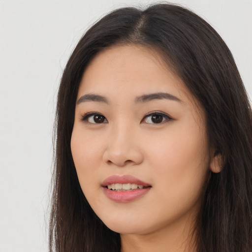 Joyful asian young-adult female with long  brown hair and brown eyes
