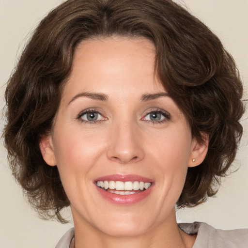 Joyful white adult female with medium  brown hair and brown eyes