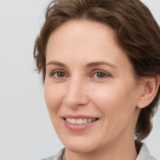 Joyful white adult female with medium  brown hair and brown eyes