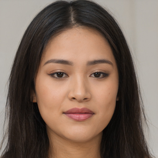 Joyful latino young-adult female with long  brown hair and brown eyes