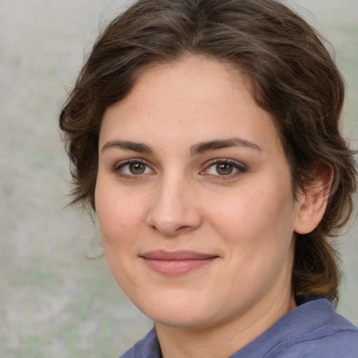 Joyful white young-adult female with medium  brown hair and green eyes