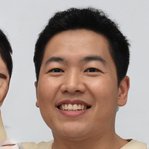 Joyful asian young-adult male with short  black hair and brown eyes