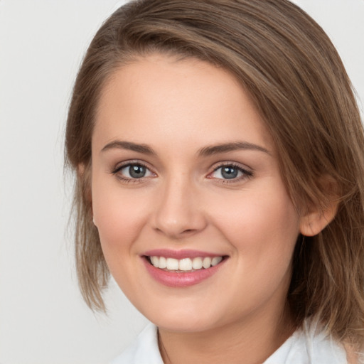 Joyful white young-adult female with medium  brown hair and green eyes