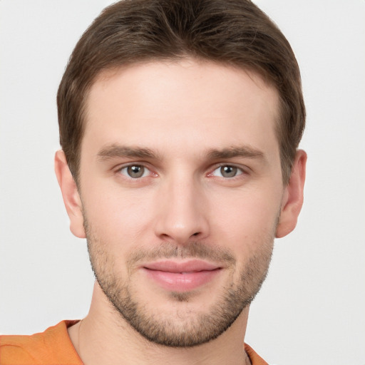 Joyful white young-adult male with short  brown hair and grey eyes