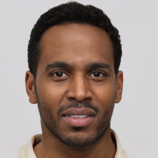 Joyful black young-adult male with short  brown hair and brown eyes