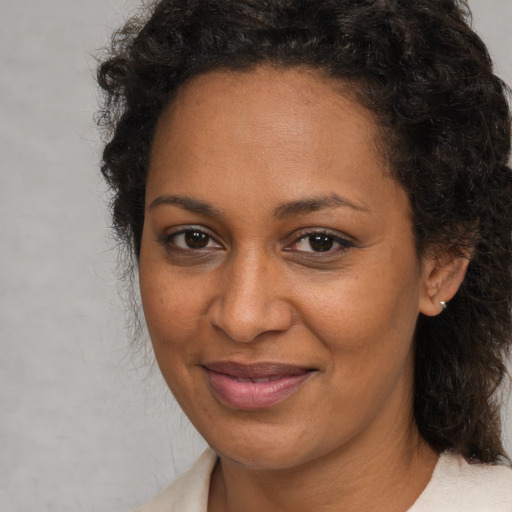 Joyful black adult female with medium  brown hair and brown eyes