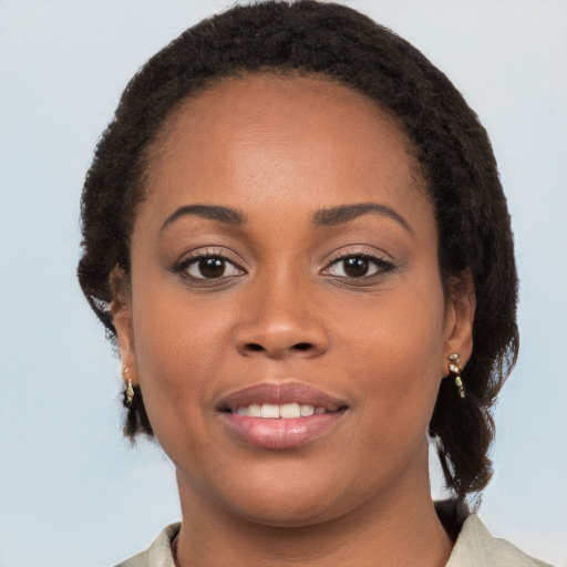 Joyful black young-adult female with long  brown hair and brown eyes