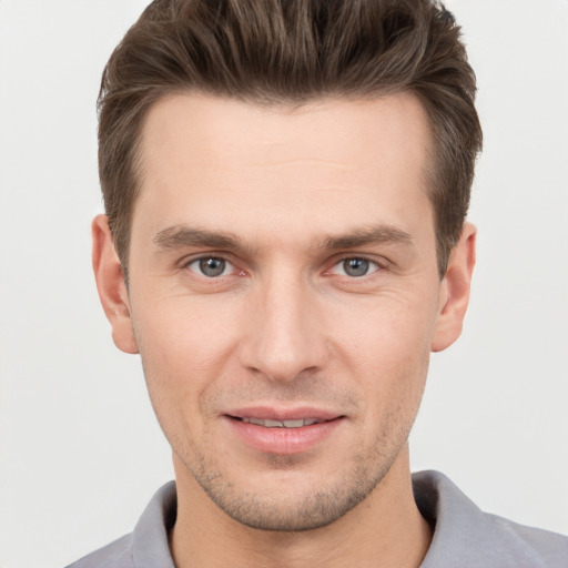 Joyful white young-adult male with short  brown hair and grey eyes