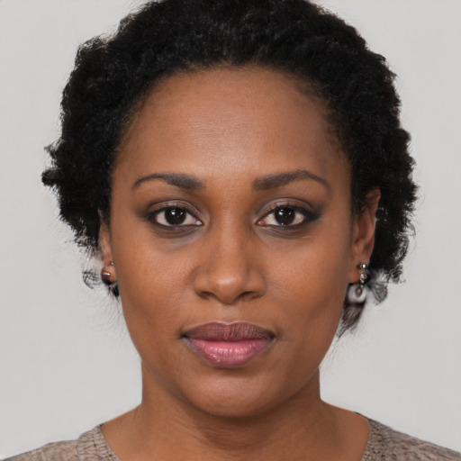 Joyful black young-adult female with short  brown hair and brown eyes