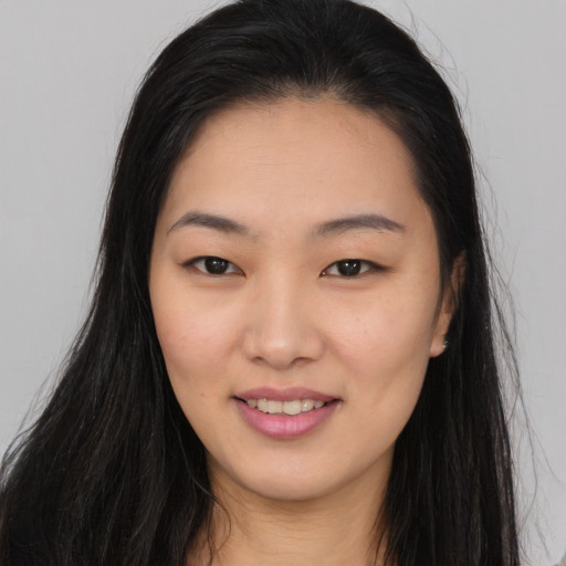 Joyful asian young-adult female with long  brown hair and brown eyes
