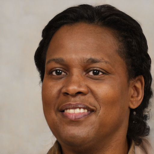 Joyful black adult female with medium  brown hair and brown eyes