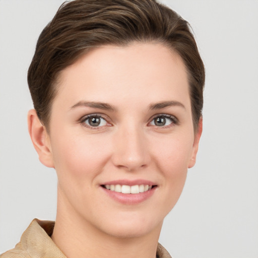 Joyful white young-adult female with short  brown hair and grey eyes