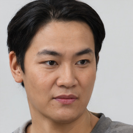 Joyful asian young-adult male with short  black hair and brown eyes