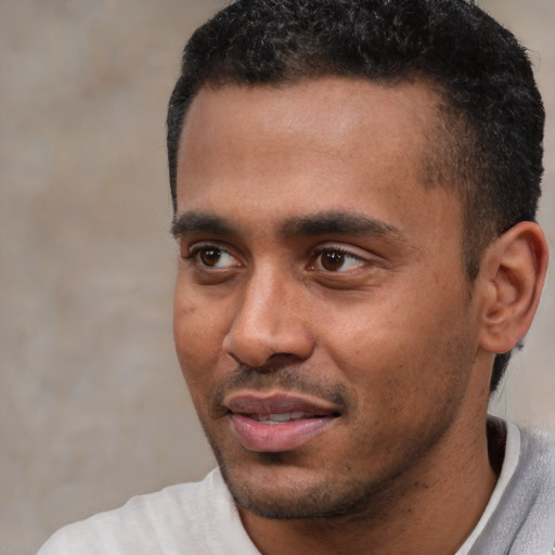 Joyful black young-adult male with short  black hair and brown eyes