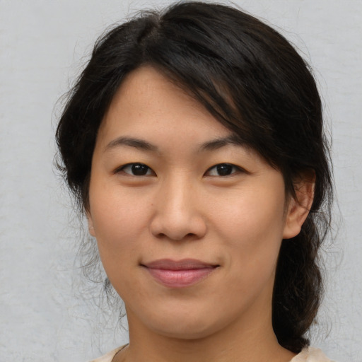 Joyful asian young-adult female with medium  brown hair and brown eyes