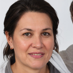 Joyful white adult female with medium  brown hair and brown eyes