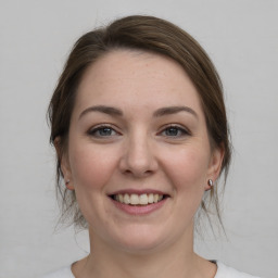 Joyful white young-adult female with medium  brown hair and green eyes