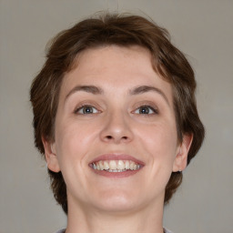 Joyful white young-adult female with medium  brown hair and green eyes