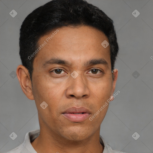 Joyful latino young-adult male with short  brown hair and brown eyes