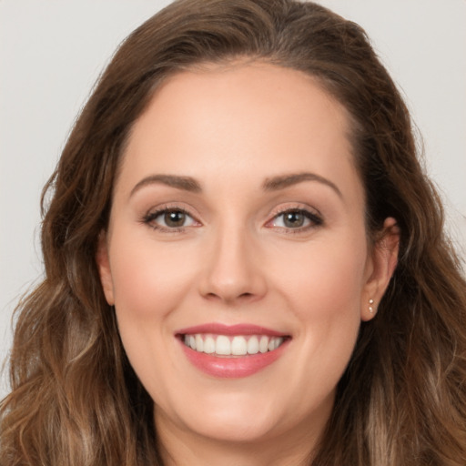 Joyful white young-adult female with long  brown hair and brown eyes