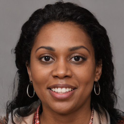 Joyful black young-adult female with long  brown hair and brown eyes