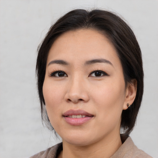 Joyful asian adult female with medium  brown hair and brown eyes