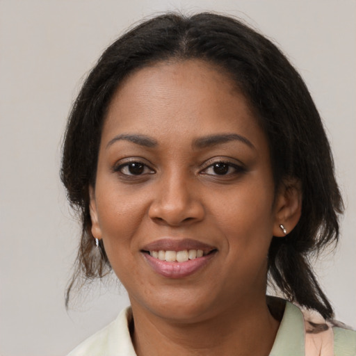 Joyful black young-adult female with medium  brown hair and brown eyes