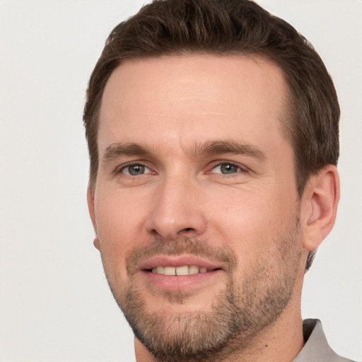 Joyful white young-adult male with short  brown hair and grey eyes