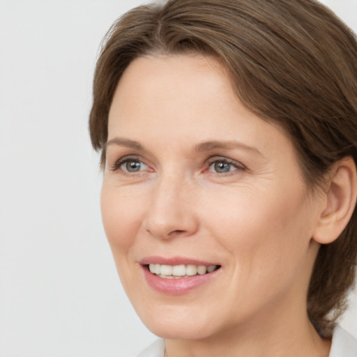 Joyful white adult female with medium  brown hair and green eyes