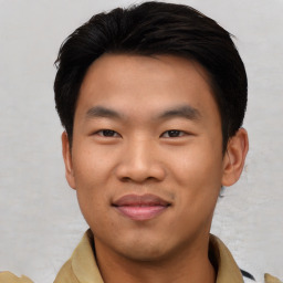 Joyful asian young-adult male with short  black hair and brown eyes