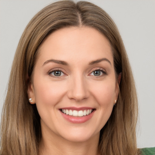 Joyful white young-adult female with long  brown hair and green eyes