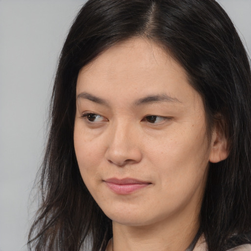 Joyful asian young-adult female with long  brown hair and brown eyes