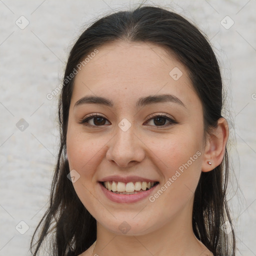 Joyful white young-adult female with long  brown hair and brown eyes