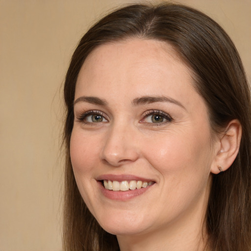 Joyful white young-adult female with long  brown hair and brown eyes