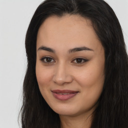 Joyful latino young-adult female with long  brown hair and brown eyes