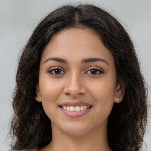 Joyful latino young-adult female with long  brown hair and brown eyes