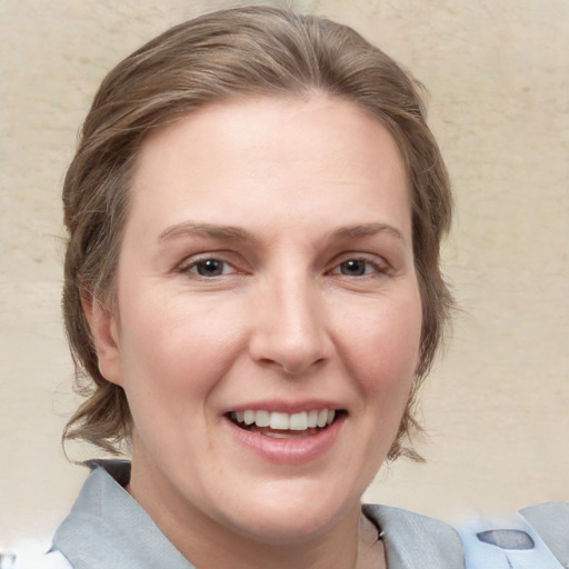 Joyful white adult female with medium  brown hair and grey eyes