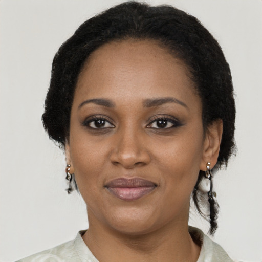 Joyful black adult female with medium  brown hair and brown eyes